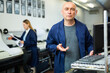 © JackF - Portrait of man printshop worker standing at computer and looking at camera.