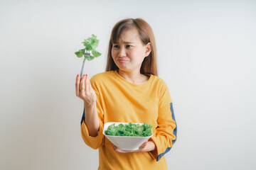 Asian woman eating a fresh salad isolated on white