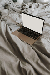 Wall Mural - Flatlay of laptop computer with blank copy space screen. Neutral grey bed linens. Aesthetic bohemian home workspace concept. Work at home.