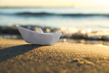 White Paper Boat On Sand Near Sea At Sunset, Closeup. Space For Text