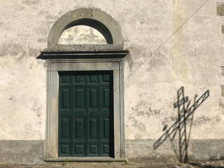 Canvas Print - Shadow of a religious cross cast onto the wall of an old church building