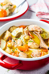 Canvas Print - Chicken stew with potatoes and carrots in red saucepan. Chicken soup with vegetables and herbs. Comfort food recipe.