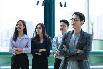 Employees and executives are standing confidently looking at the camera. Group of happy business people standing in Co Working Space.