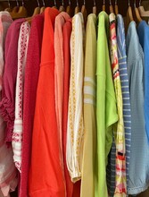 Close-up Of A Rainbow Coloured Clothes Hanging In A Wardrobe