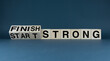 © Prazis Images - Start strong - Finish strong. The cubes form the words Start strong - Finish strong.