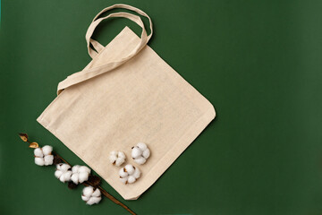 Textile eco bag and cotton flowers on paper background.