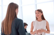 © ASDF - businesswoman with a glass of coffee discussing something with her colleague