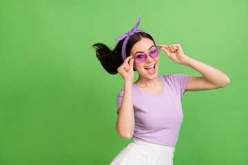 Sticker - Photo of impressed young brunette lady wear band glasses t-shirt isolated on green color background