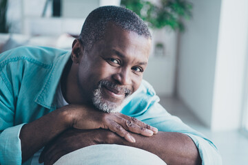 Portrait of handsome wellbeing aged man enjoy relaxation holiday in modern house living room wear denim shirt