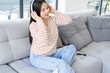 © Юля Шевцова - smiling young asian woman with closed eyes listening music in wireless headphone at modern home