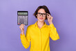 canvas print picture - Photo of nice young lady hold calculator wear yellow outfit eyewear isolated on violet color background