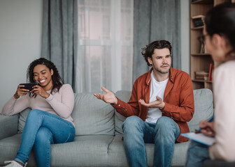 Wall Mural - Game, addiction to gadgets and social networks. Sad millennial european husband swears at black wife