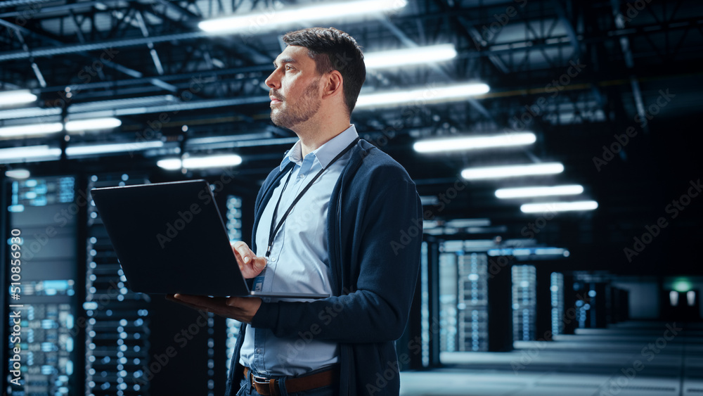 Cloud Computing Expert Successful Data Center IT Specialist Using Laptop Computer. Server Farm ...