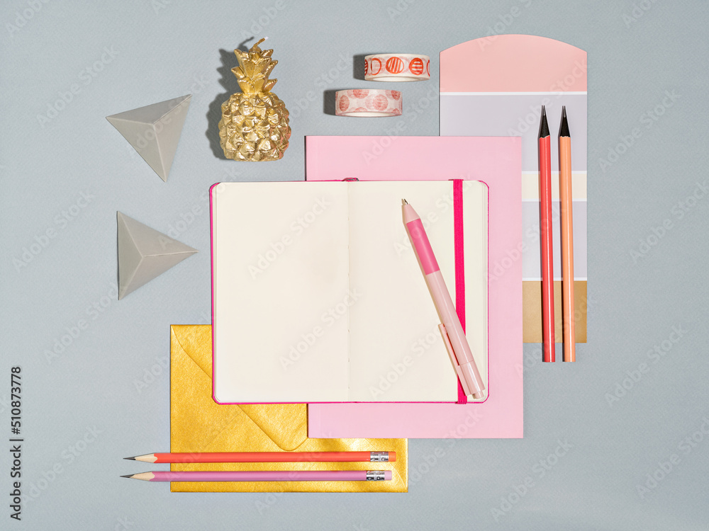 Top view of designers workplace with colour swatch and office supplies. Desk of artist or creative occupied freelance girl. Mock up of planner, to do list, sketchbook. Work from home concept.