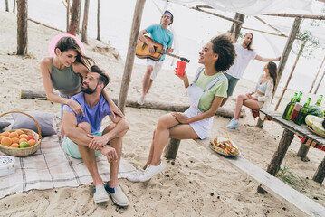 Poster - Portrait of attractive cheerful people spending day weekend pastime relax talking communicating at beach picnic outdoors