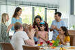 © amorn - Happy family gathering enjoying having lunch together at home. Child daughter having fun around dining table with parents, grandparents and multi-generation family