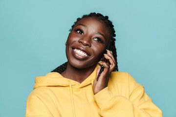 Wall Mural - Young black woman wearing hoodie talking on mobile phone