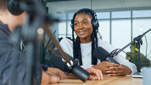 Female Host Talking To A Guest Friend On A Podcast Radio Station In The Studio. African American And European Record Podcast And Discuss Social Issues, Business Radio Show.