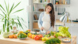 © alex_marina - Beautiful Pregnant Woman Happily Preparing a Vegetable Salad, Organic Healthy Food, in a Cozy Home Kitchen. The Concept Of Diet, Proper Nutrition, Healthy Pregnancy and People.
