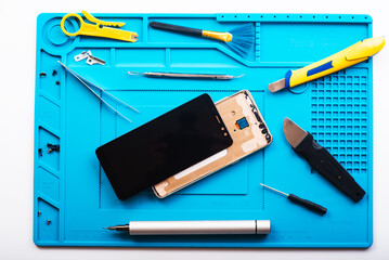 Flat lay image of dismantling the broken smart phone for preparing to repair or replace some components, Top view