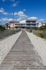 Wall Mural - Long wooden boardwalk leading off of the beach