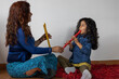 © Amilciar - Latin American music teacher giving recorder lessons to her daughter