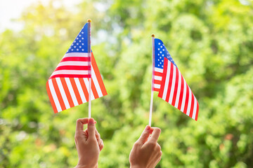 Wall Mural - hand holding United States of America flag on green background. USA holiday of Veterans, Memorial, Independence ( Fourth of July) and Labor Day concept