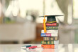 Graduate study abroad program to broaden learner's world view, education concept Graduation cap, foreign books on a table, depicting students attempt to study from a distance or learning from home.