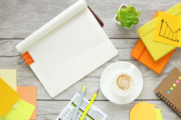 open notepad, coffee cup, yellow and orange notepad and calendar on wooden background, spiral notepad on table Business, planning, education, morning life, work from home, concept Top view Flat mockup