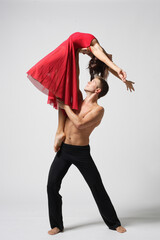 Wall Mural - young couple of modern ballet dancers posing on clear studio background