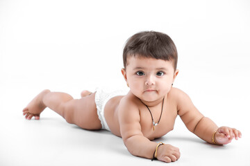 Wall Mural - Indian baby girl playing on white background.