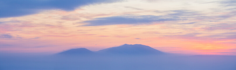 Wall Mural - Winter arctic landscape. View of the snow-capped mountains at sunset. Cold winter weather. Frosty fog over the tundra. Arctic nature. Mount Dionysius, Chukotka, Siberia, Far North of Russia. Panorama.