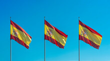 Three Flags Of Spain With A Beautiful Blue Sky