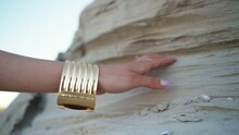 Beautiful Female Hand With An Oriental Gold Bracelet On A Background Of Sand. Jewelry Concept.