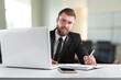 © BillionPhotos.com - Smiling young businessman sitting at worktable at modern office,