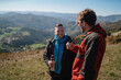 © Halfpoint - Two paragliders men standing on the top of mountain and drinking tea.