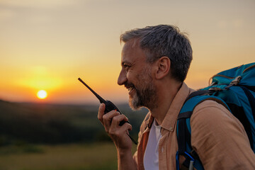 Man standing on a hill and talking on walkie-talkie