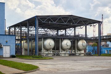 Carbon dioxide production plant. Cryogenic tank co2 carbonic acid distillation storage. Part of petrochemical plant three cryogenic tanks with CO2 under canopy heat protection export filling device.