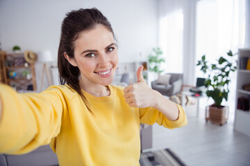 Sticker - Photo of confident blogger lovely cute lady raise thumb up take selfie wear yellow pullover comfortable home indoors