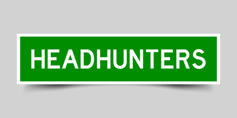 Wall Mural - Sticker label with word headhunters in green color on gray background