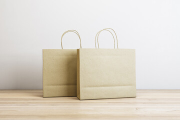 Poster - Clean paper shopping bags on white concrete and wooden surface background with mock up place. Purchase and retail concept. 3D Rendering.