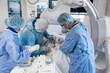 © Игорь Гончаров - Doctors in the operating room perform a heart operation to introduce a pacemaker. The doctor in the operating room spreads the incision with clamps. Doctors perform heart surgery with the utmost care