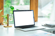 © Phushutter - Blank white laptop screen of Stylish workspace with laptop computer, office supplies, plant.