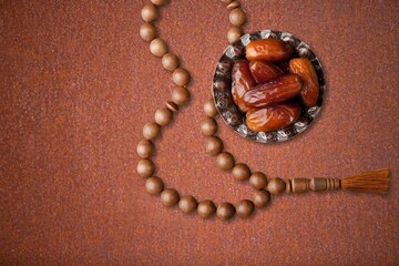 Poster - Arabian dates in an antique metal bowl with Islamic prayer beads. Ramadan Kareem, Muslim festival objects and background.