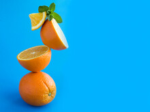 Oranges Fruit Stacked Pyramid On The Blue Background. Copy Space. Closeup.