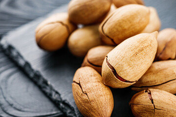 delicious fresh pecans on a black rustic wooden background