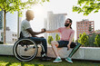 © Vane Nunes - Multiethnic people with disabilities greeting each other outdoor - Focus on right man with leg prosthesis