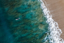 Male Surfer Paddles On Board On Oahu, Hawaii