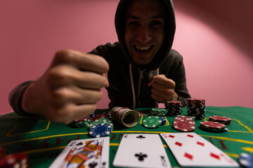 Wall Mural - man at green playing table with gambling chips and cards playing poker and blackjack in casino