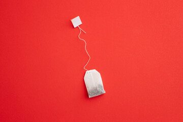 Tea bag with label on red background, space for text